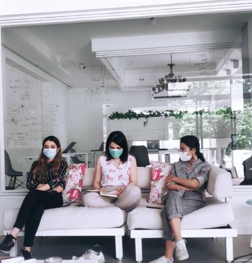 The Komodaa team sitting together, masked, during the pandemic